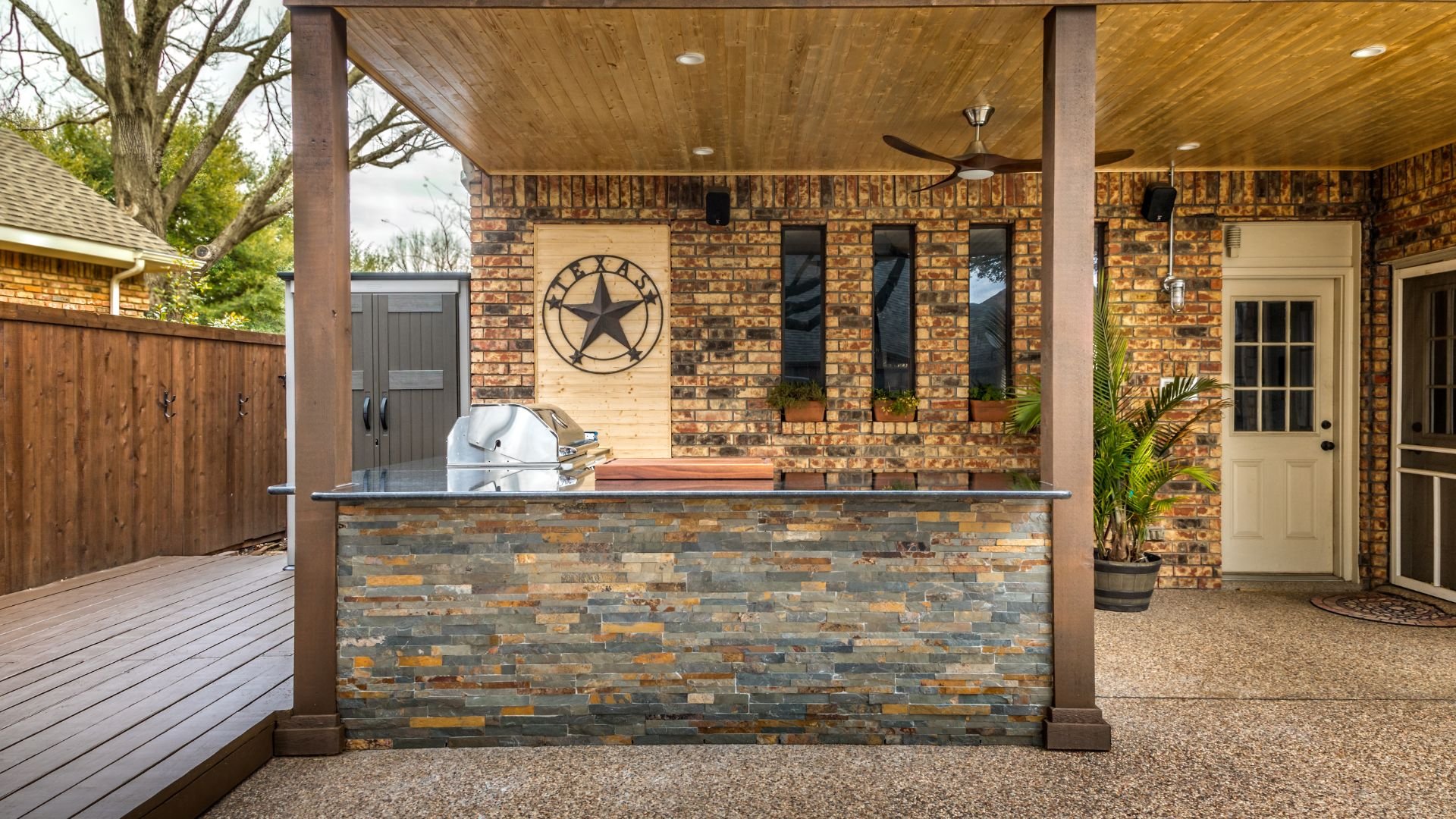 Outdoor kitchen with stone countertop, grill, and Texas star decoration